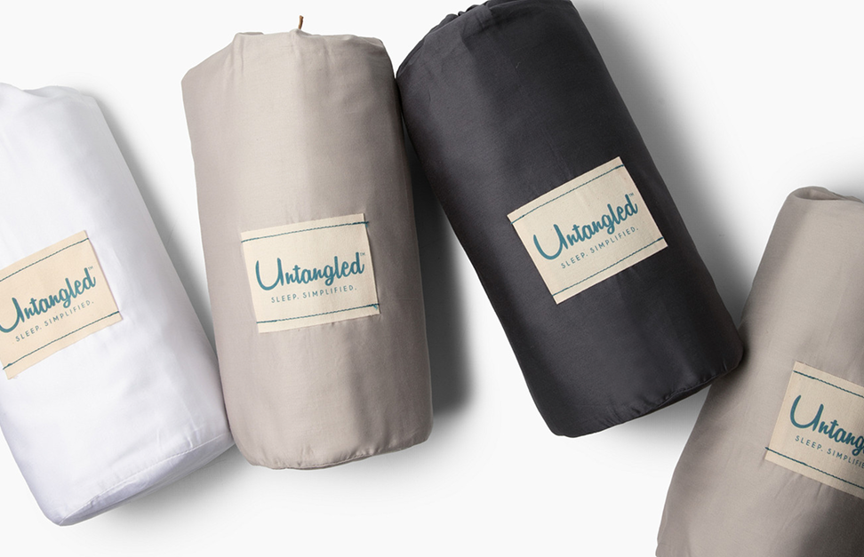 Folded bedding sets with 'Untangled' labels on a white background